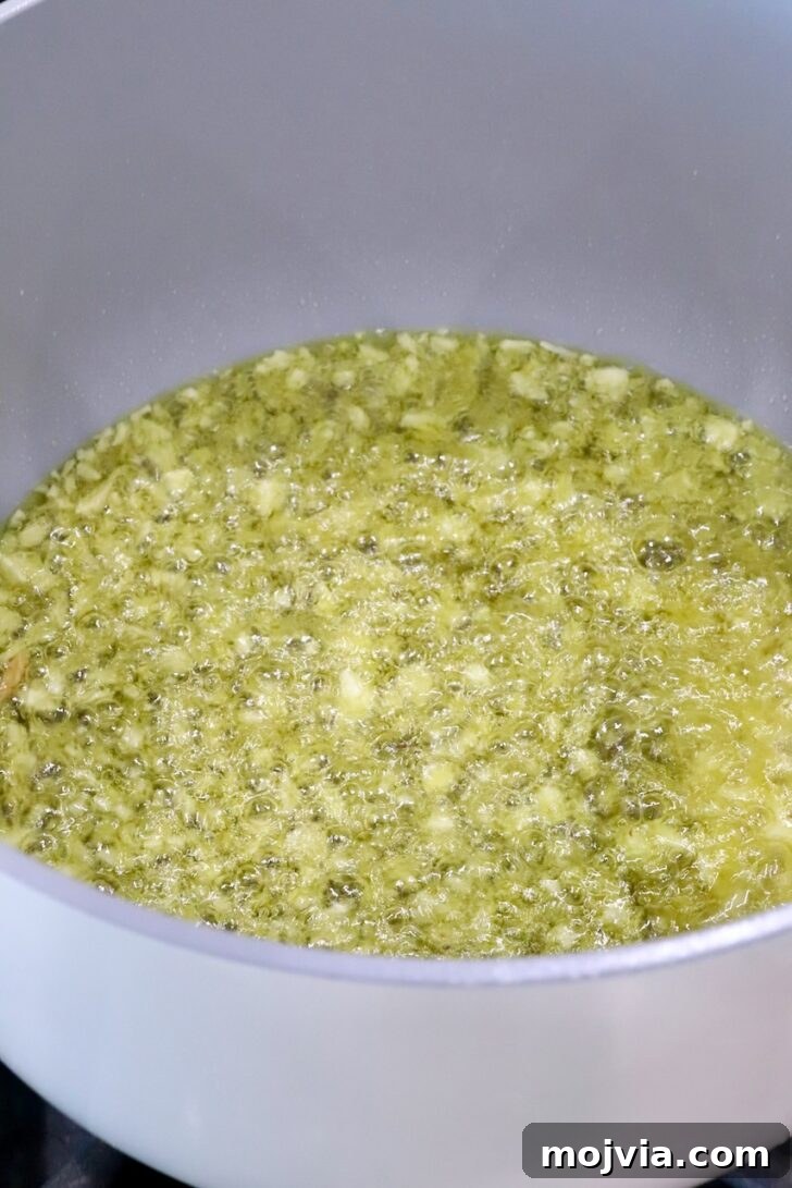 Calabrian Chili Crisp: Spicy Oil Recipe & Flavor Uses 7 minced garlic in oil in a white pot