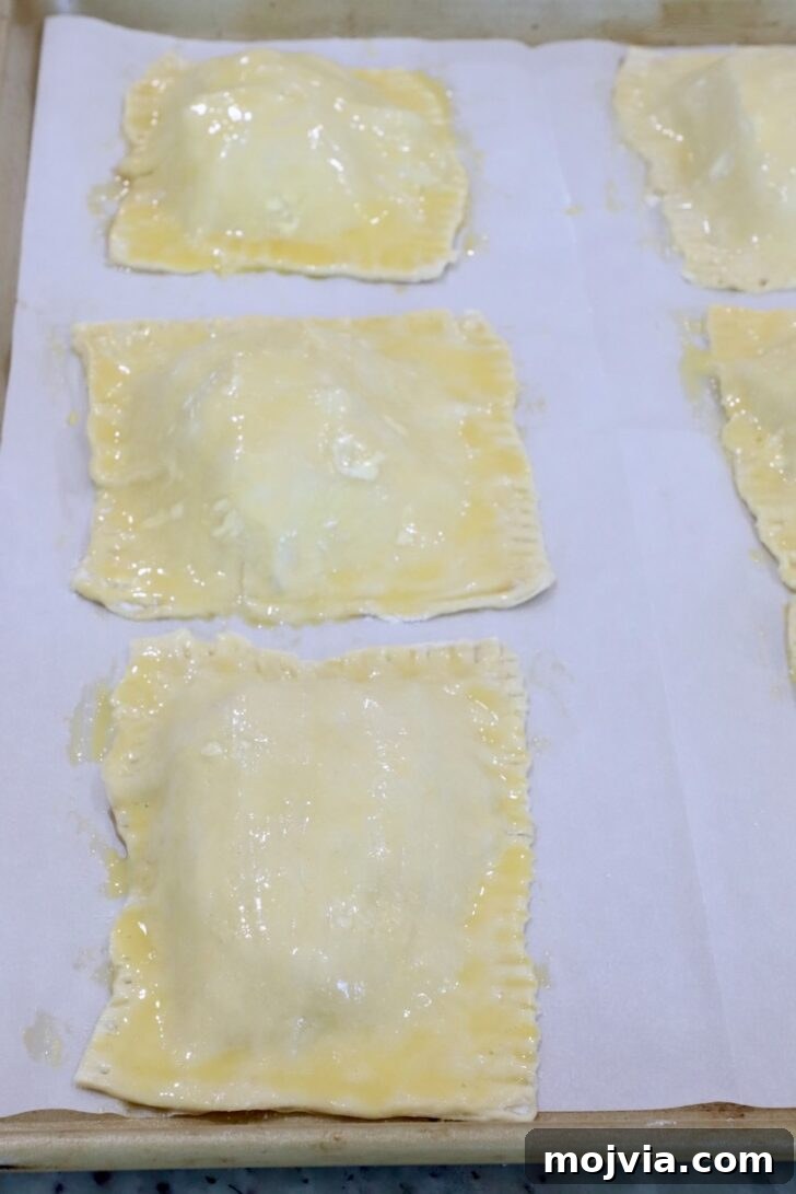 Gorgonzola and Pear Tart Recipe: Savory-Sweet Rustic Tart 13 unbaked tarts on a parchment-lined baking sheet brushed with egg wash