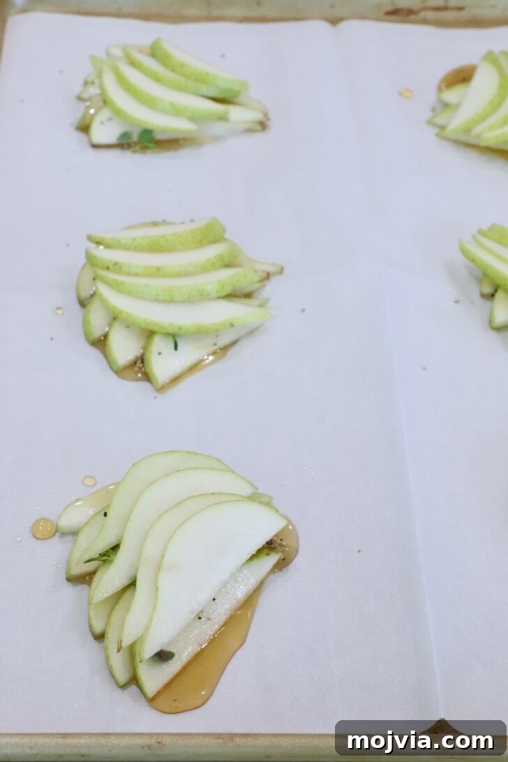 Gorgonzola and Pear Tart Recipe: Savory-Sweet Rustic Tart 10 sliced pears stacked up on a parchment-lined baking sheet