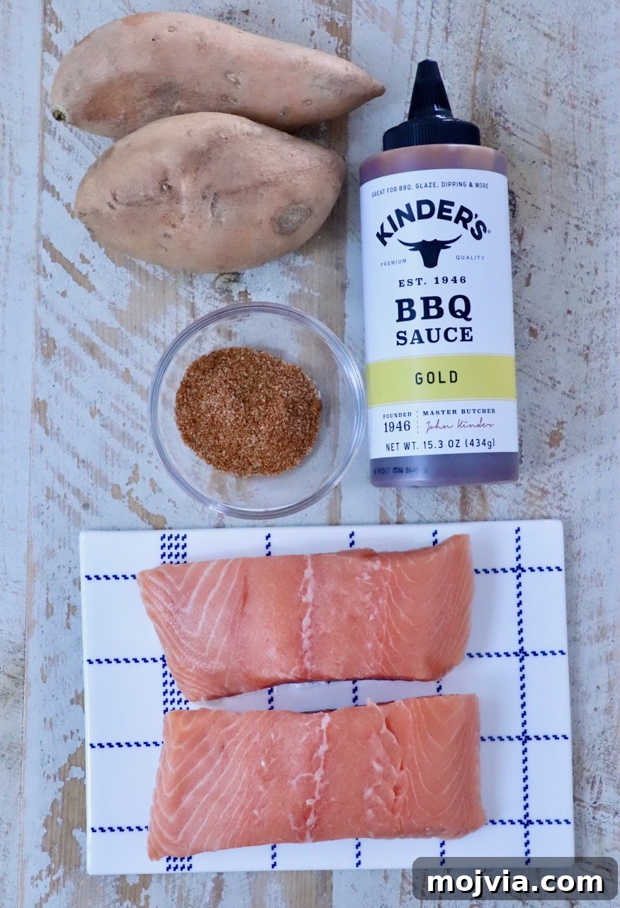 Grilled Salmon with Maple-Glazed Sweet Potatoes 5 Raw salmon fillets on a checkered plate, accompanied by sweet potatoes, BBQ sauce, and a bowl of spices on a rustic wooden surface.