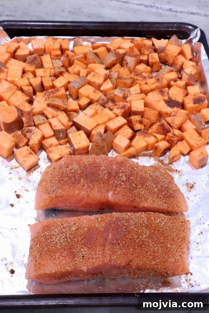 Grilled Salmon with Maple-Glazed Sweet Potatoes 6 diced seasoned sweet potatoes on a foil lined baking sheet with two pieces of seasoned salmon filets