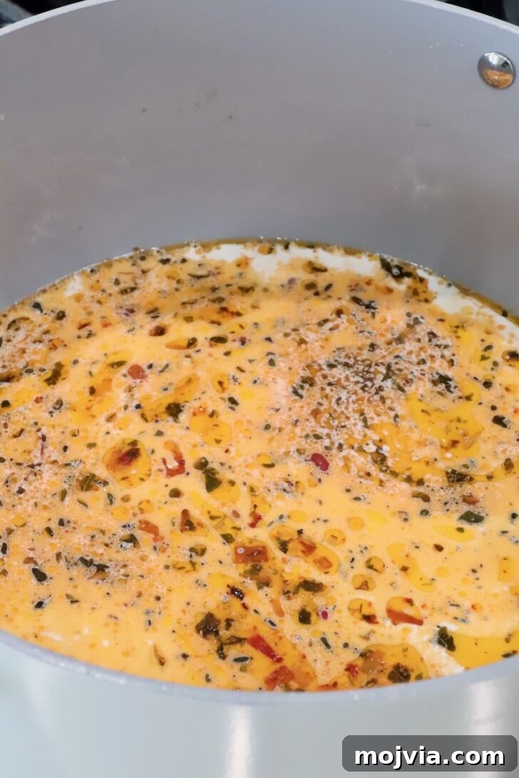 Creamy Tuscan Chicken Pasta Recipe with Sun-Dried Tomatoes 9 creamy tuscan pasta sauce in a pan on the stove
