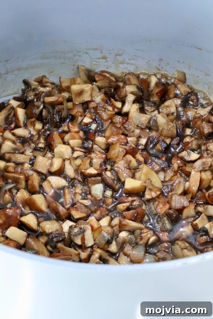 Savory Mushroom Jam Recipe for Spreading and Cooking 10 cooked mushrooms in a pot with maple syrup, brown sugar, and vinegar