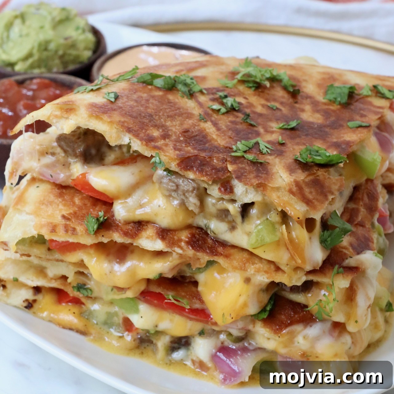 steak quesadilla cut into triangles and stacked up on a plate