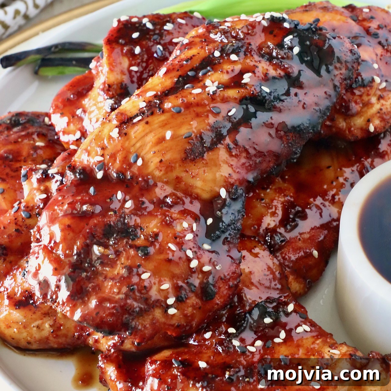 bbq glazed grilled chicken stacked up on a plate