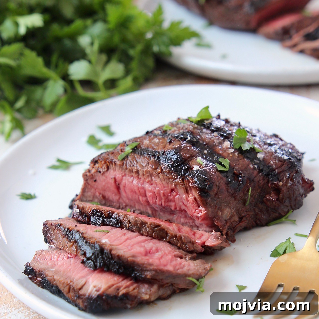 sliced grilled steak on plate with fork