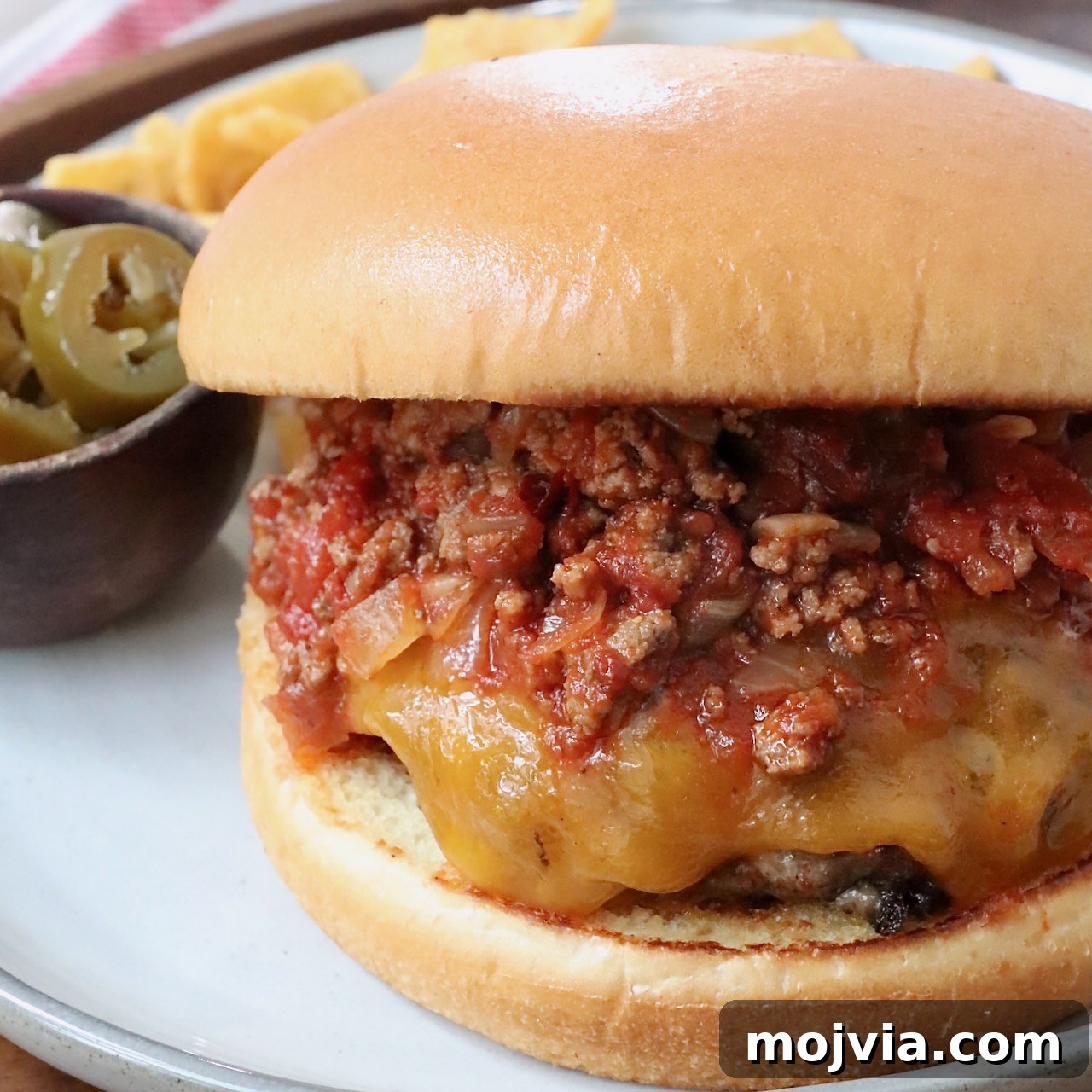cheeseburger topped with chili on plate