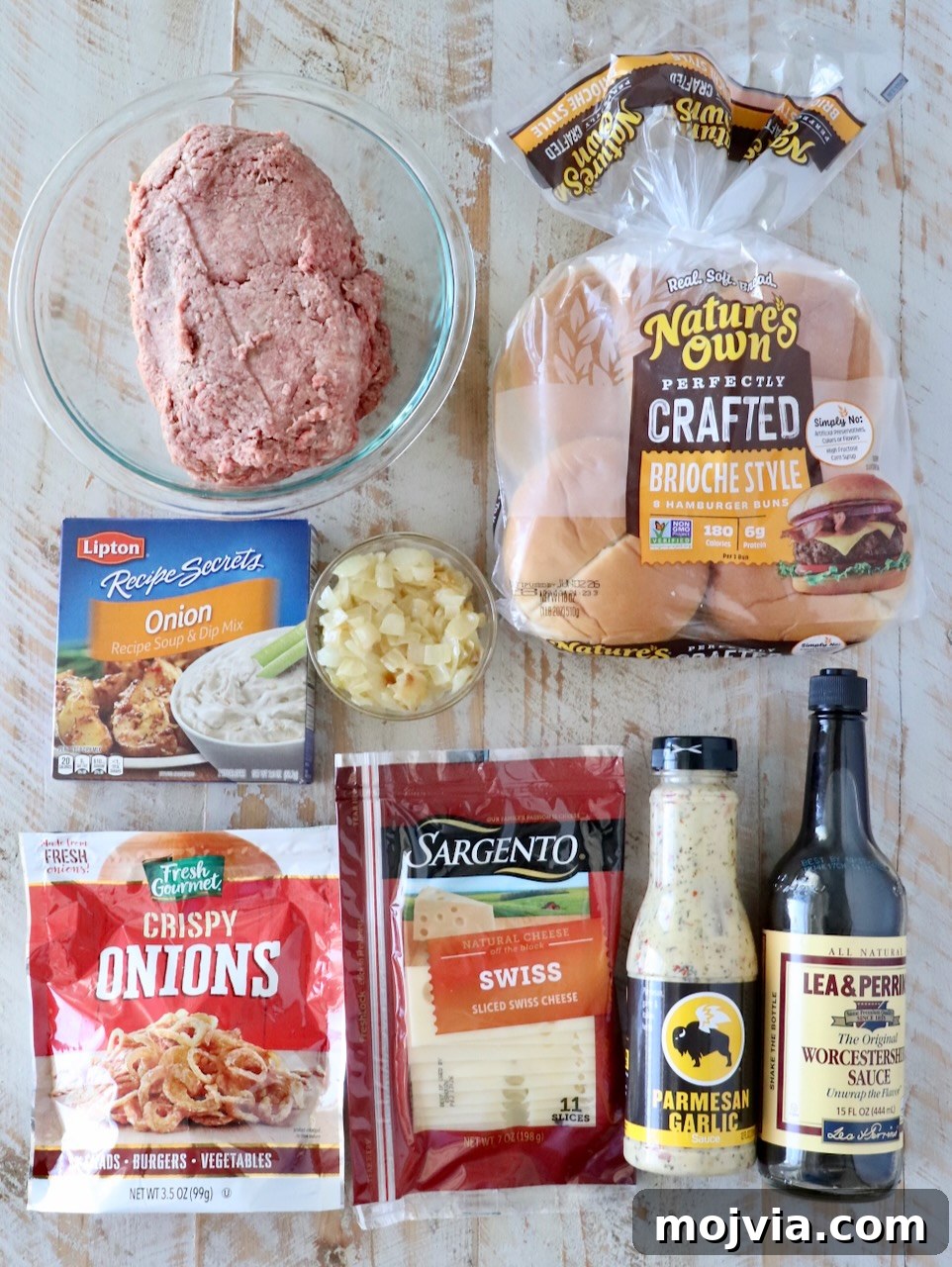 French Onion Burger Recipe with Caramelized Onions & Gruyère 5 ingredients for french onion burgers on a white wood board