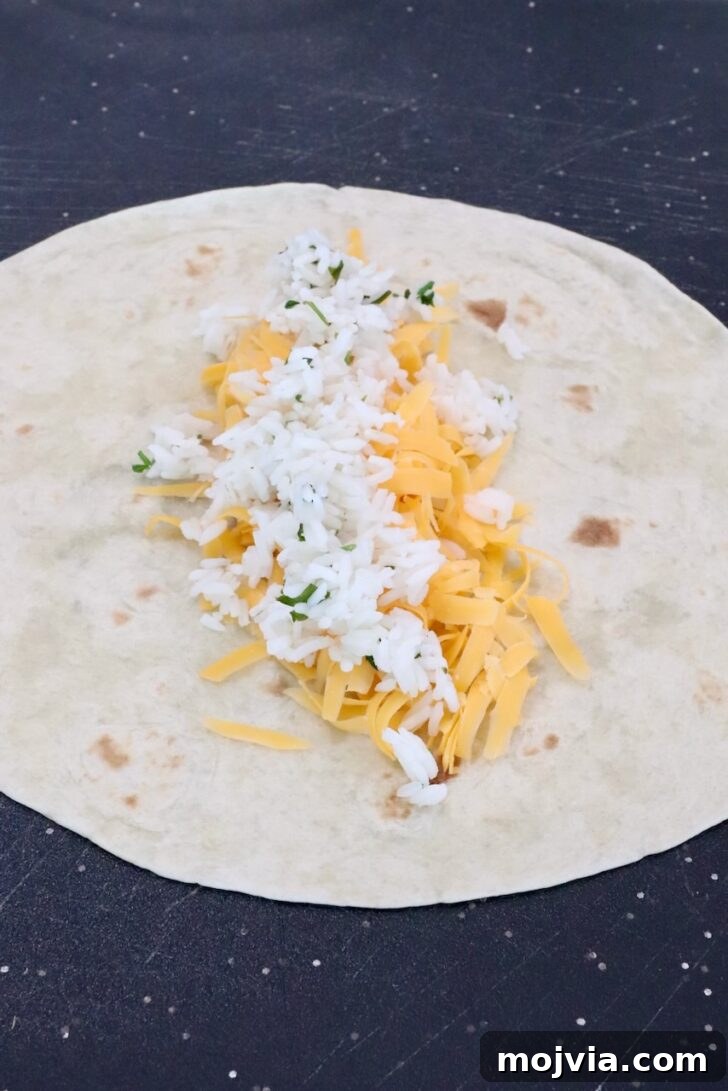 Melted Cheese, Beans & Rice Burrito Recipe for Weeknights 9 shredded cheddar cheese and cilantro lime rice in the middle of a tortilla