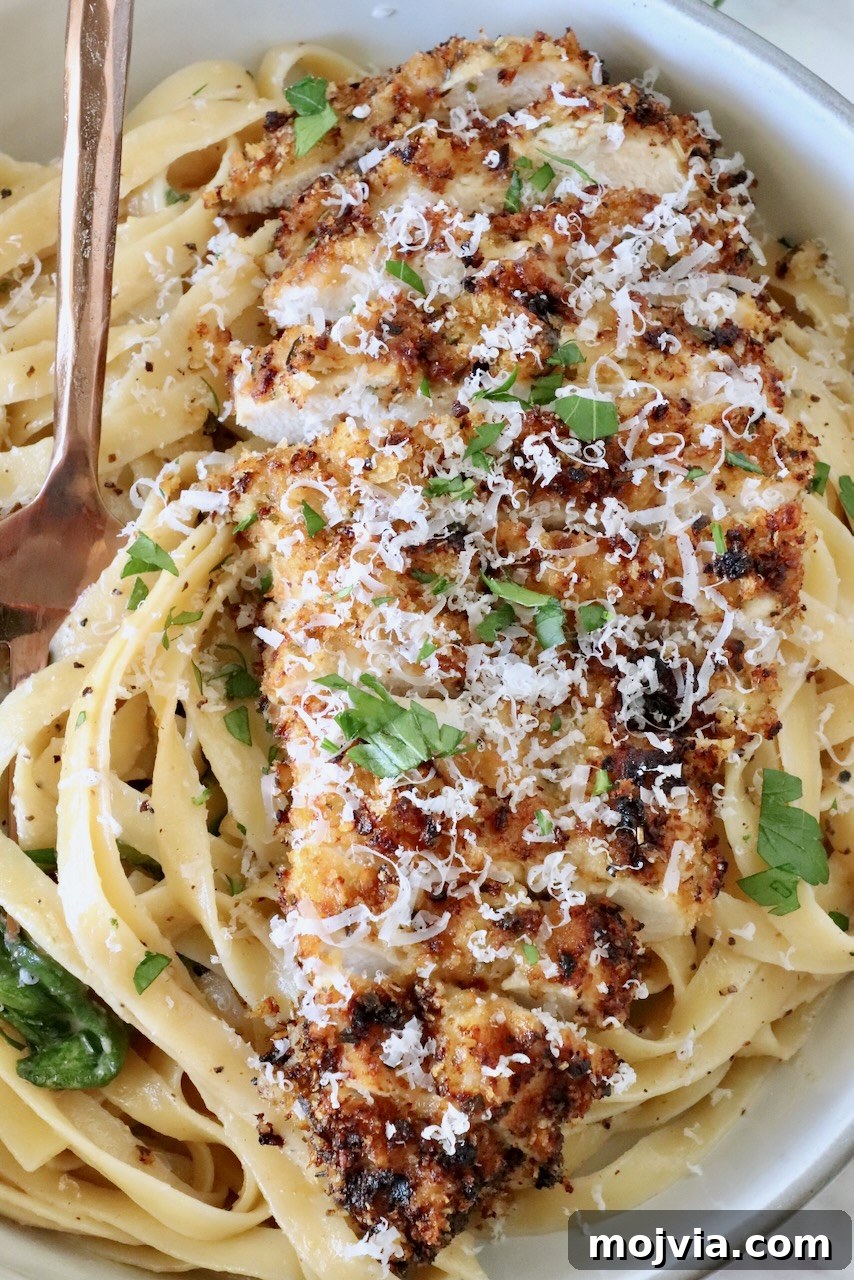 Creamy Chicken Caesar Pasta Recipe for Weeknight Dinners 2 crispy sliced chicken on top of creamy noodles in a bowl with a fork