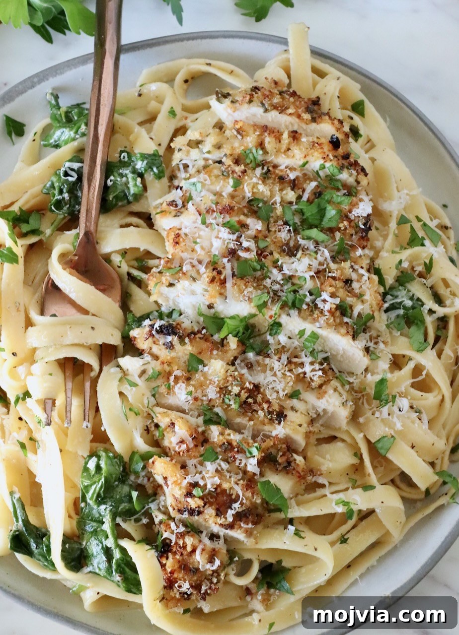 Creamy Chicken Caesar Pasta Recipe for Weeknight Dinners 12 chicken caesar pasta in a bowl with a fork, topped with fresh parsley and parmesan cheese