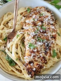 Creamy Chicken Caesar Pasta Recipe for Weeknight Dinners 13 crispy chicken on top of creamy fettuccine pasta in a bowl with a fork