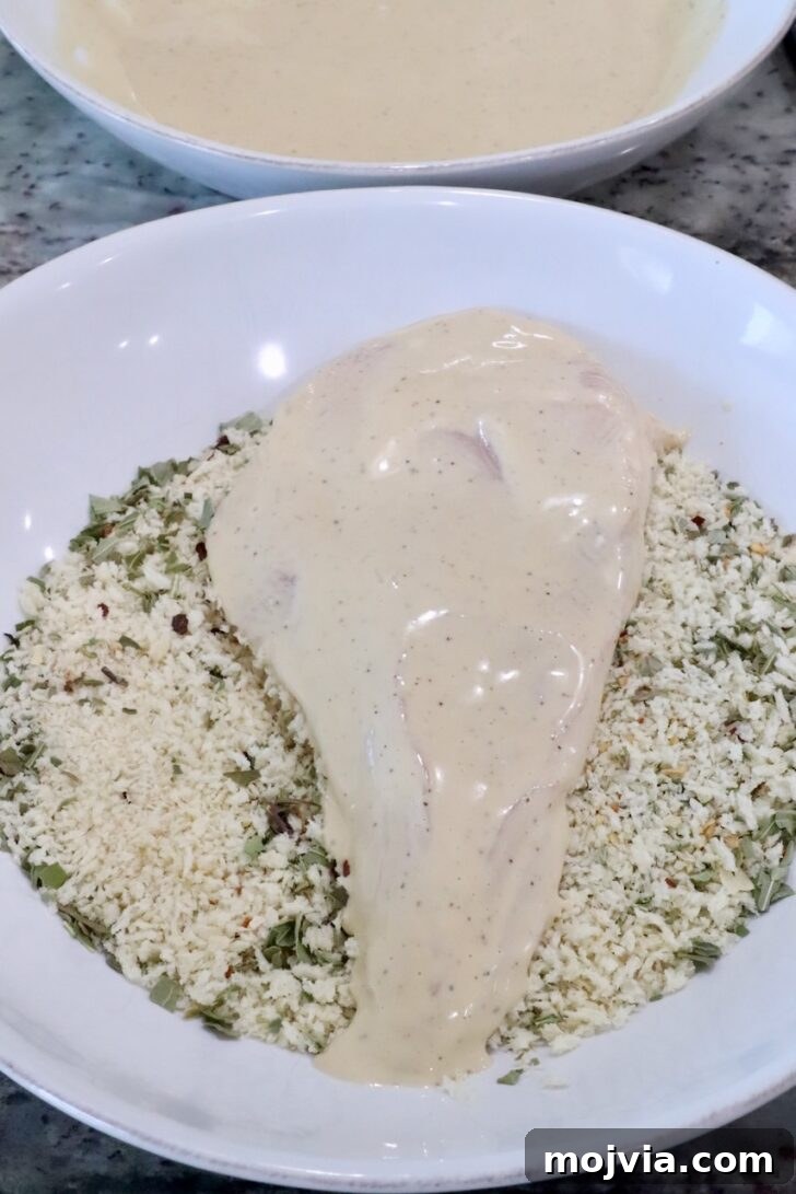 Creamy Chicken Caesar Pasta Recipe for Weeknight Dinners 7 a chicken breast coated in caesar dressing in a bowl of Italian seasoned breadcrumbs