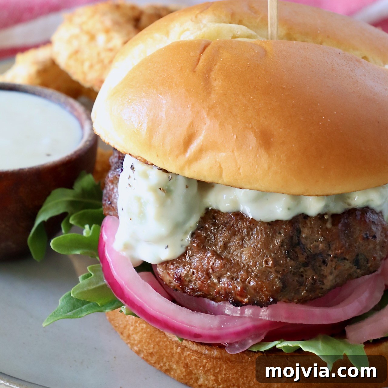 Complete Burger Guide: Techniques, Recipes & Toppings for Perfect Patties 14 burger on plate with pickled onions and blue cheese