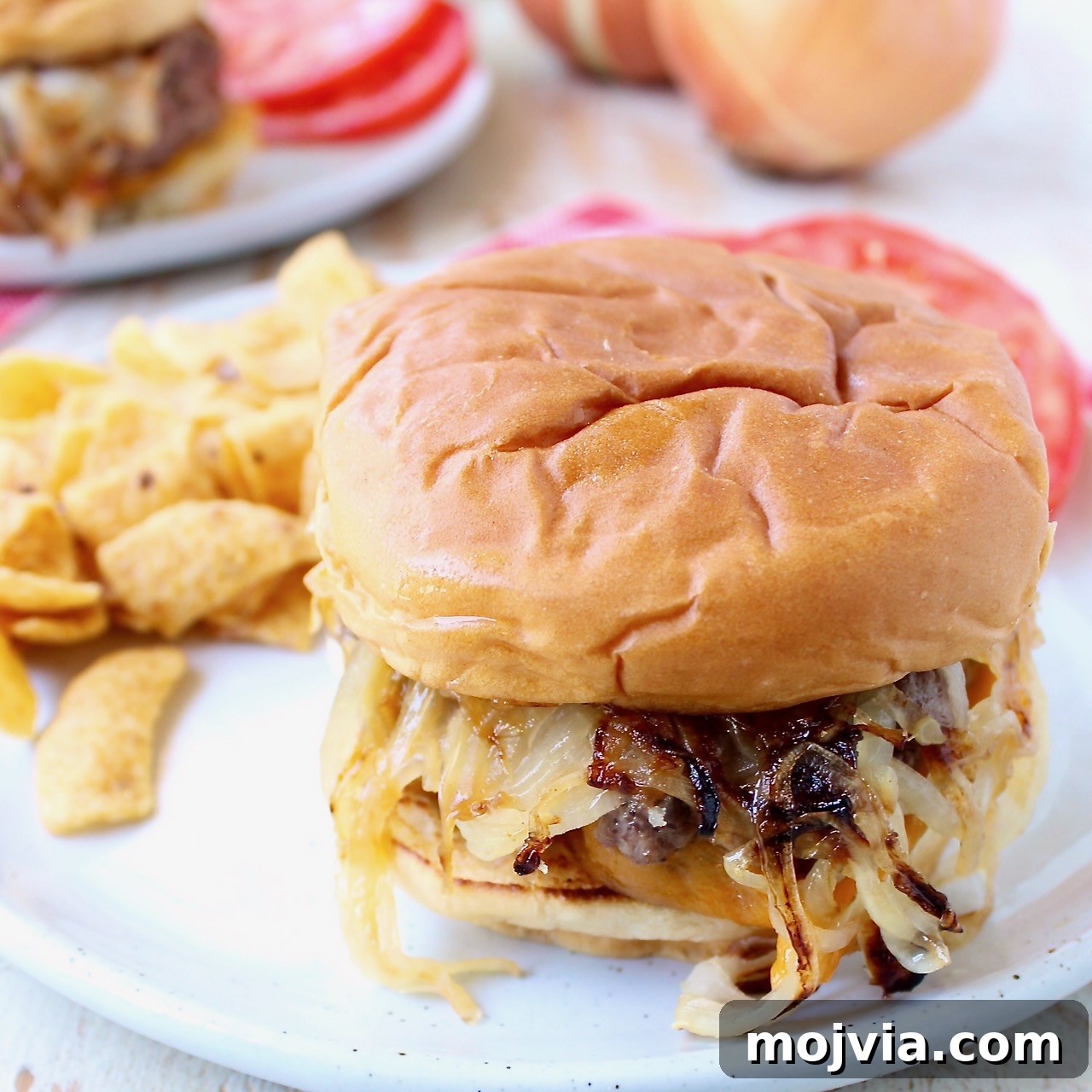 Complete Burger Guide: Techniques, Recipes & Toppings for Perfect Patties 9 onion fried burger on plate with chips and sliced tomatoes