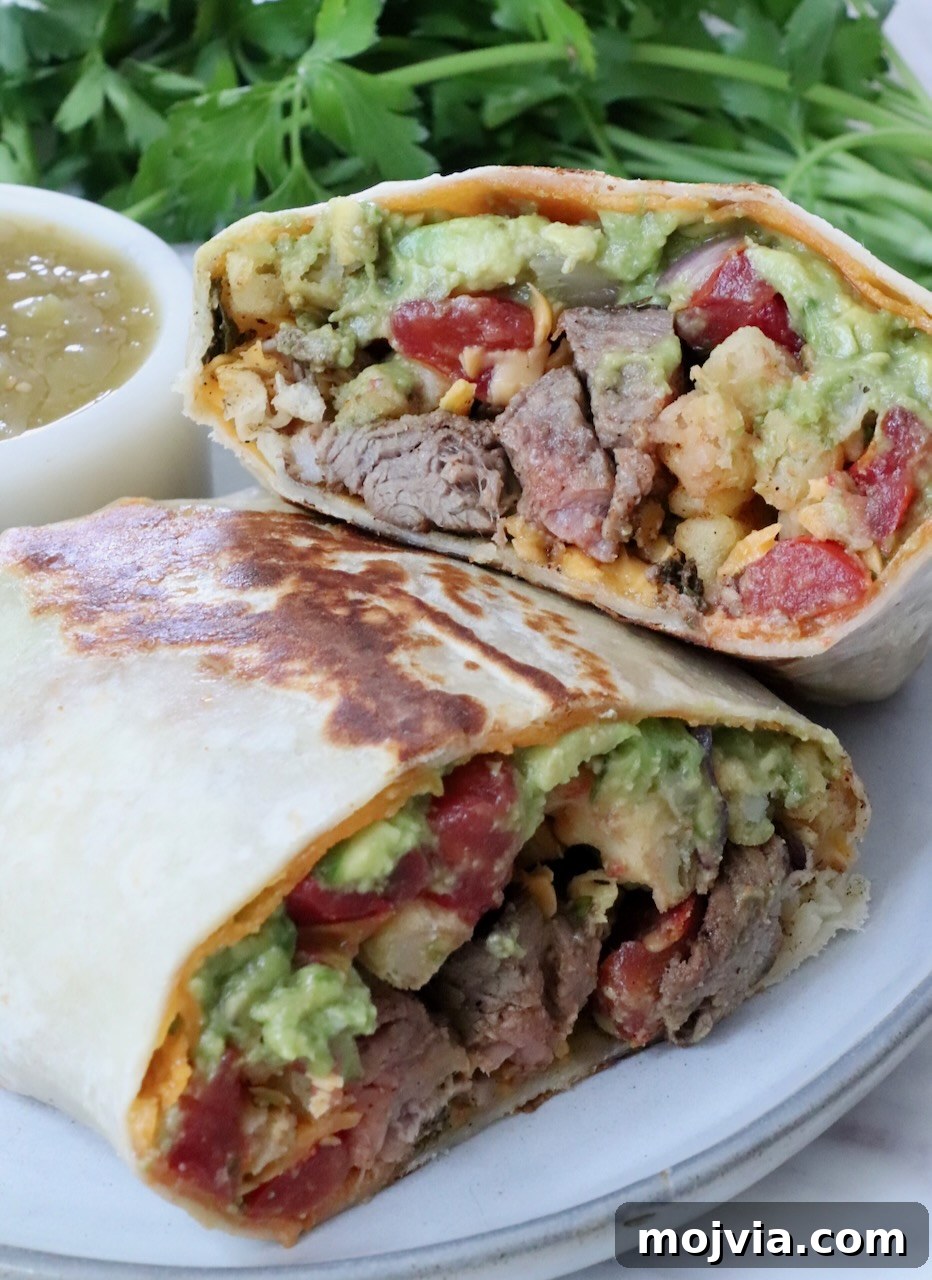 Authentic California Burrito Recipe with Carne Asada and Fries 2 California burrito with carne asada and french fries cut in half and stacked up on a plate with a small bowl of salsa and fresh cilantro in the background