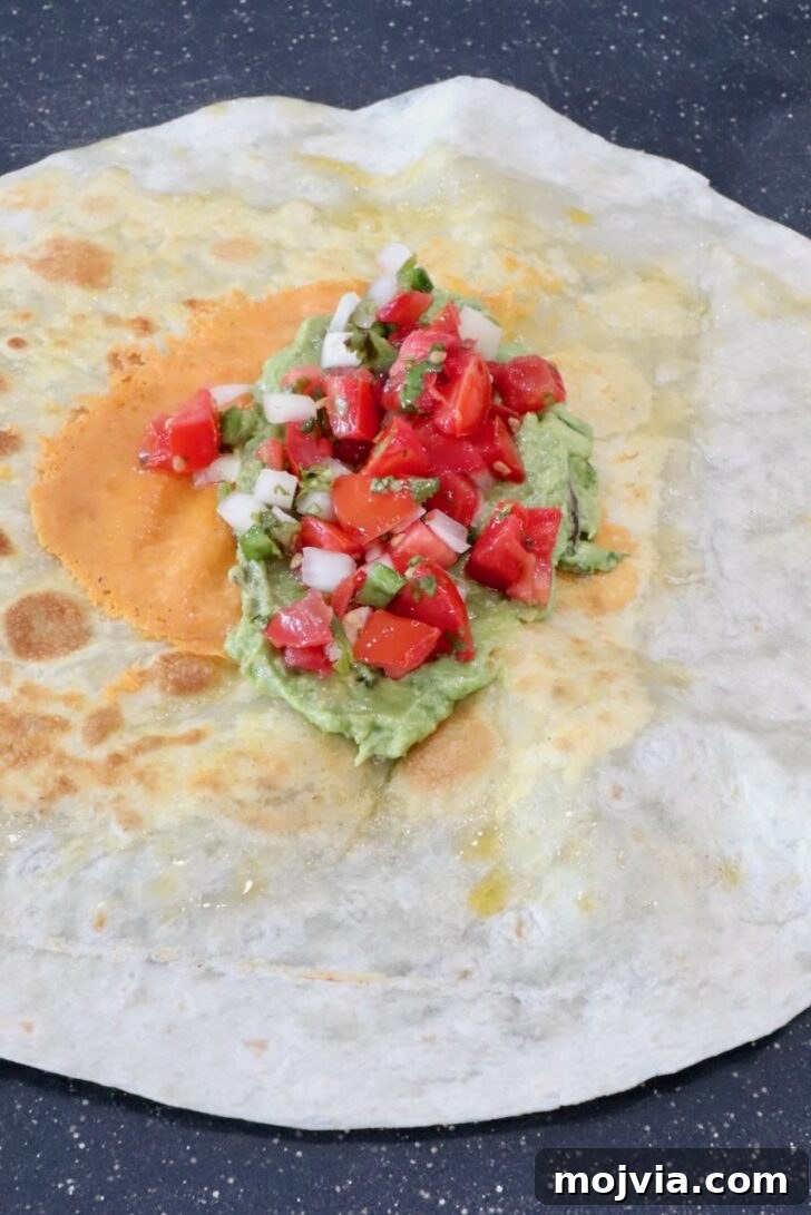 Authentic California Burrito Recipe with Carne Asada and Fries 7 guacamole and pico de gallo in the middle of a tortilla