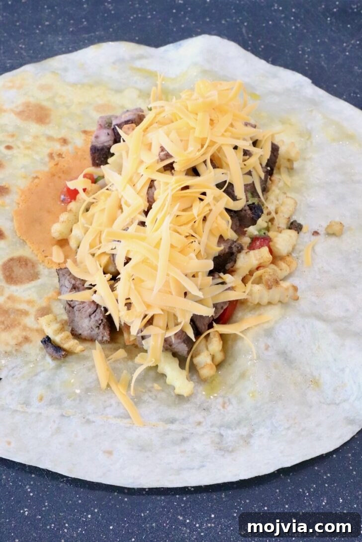 Authentic California Burrito Recipe with Carne Asada and Fries 9 shredded cheese on top of carne asada in the middle of a tortilla