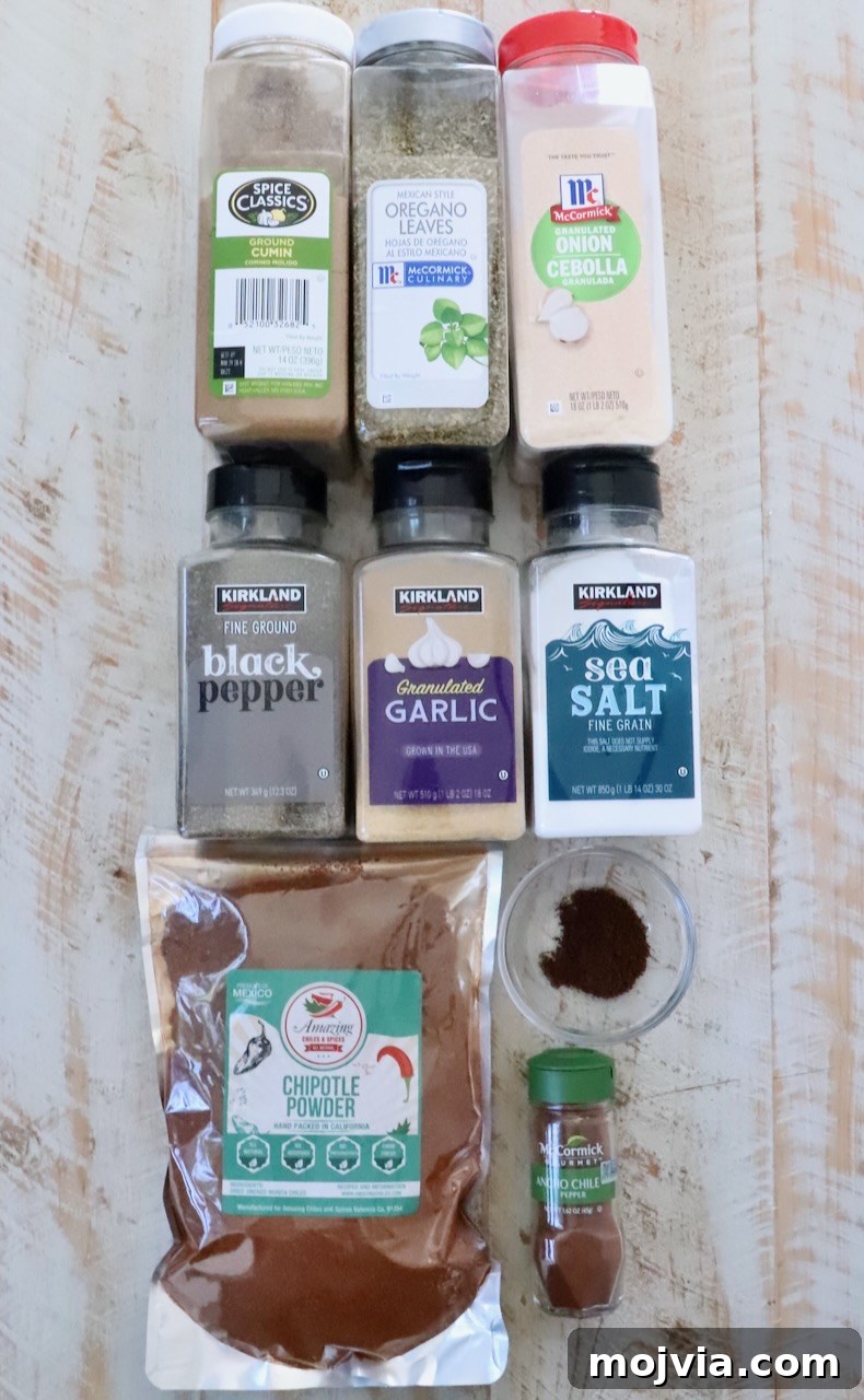 Authentic Barbacoa Seasoning Blend for Tacos and Burritos 5 spices in plastic containers lined up on a white wood board