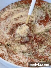 Authentic Barbacoa Seasoning Blend for Tacos and Burritos 8 dried herbs and spices mixed together in a bowl with a spoon