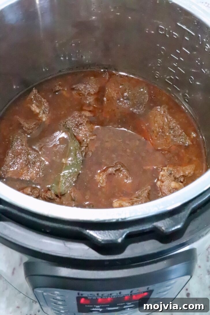 Instant Pot Beef Barbacoa: Tender Mexican Shredded Beef 9 cooked beef in broth in an Instant Pot