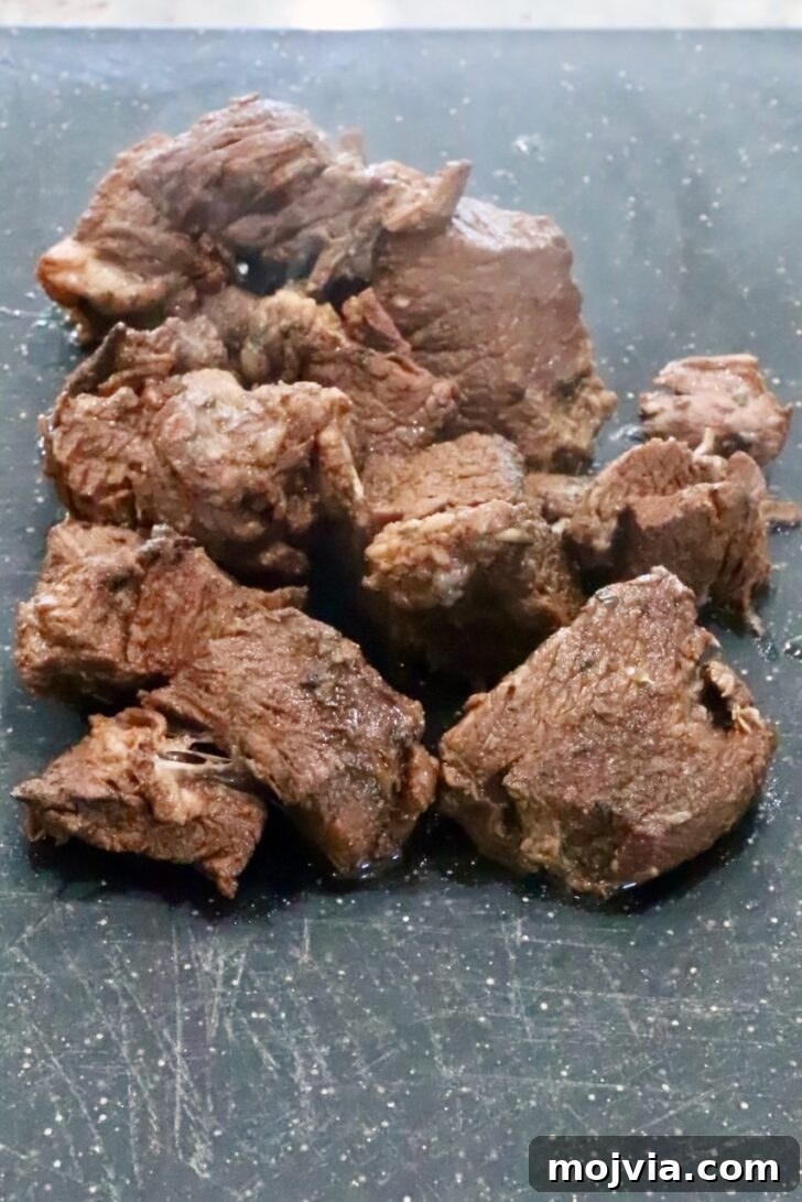Instant Pot Beef Barbacoa: Tender Mexican Shredded Beef 10 cooked chunks of beef on a cutting board