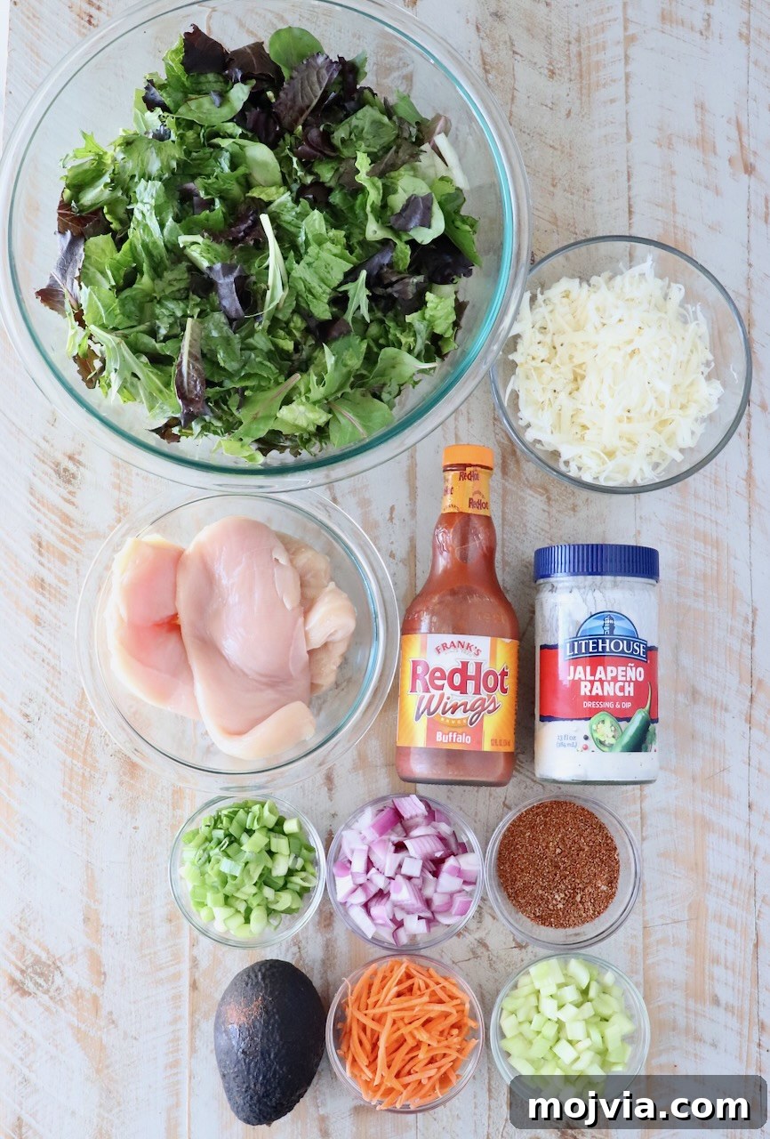 Spicy Buffalo Chicken Salad with Blue Cheese Dressing 5 ingredients for a buffalo chicken salad on a white wood board