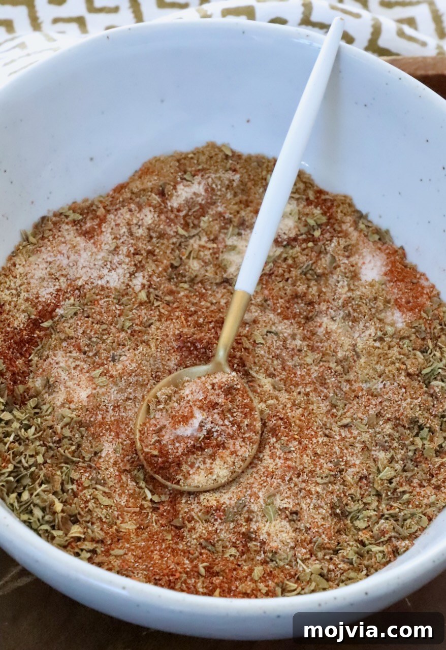 Homemade Chicken Taco Seasoning Mix for Flavorful Tacos 2 dried herbs and spices mixed together in a bowl with a spoon
