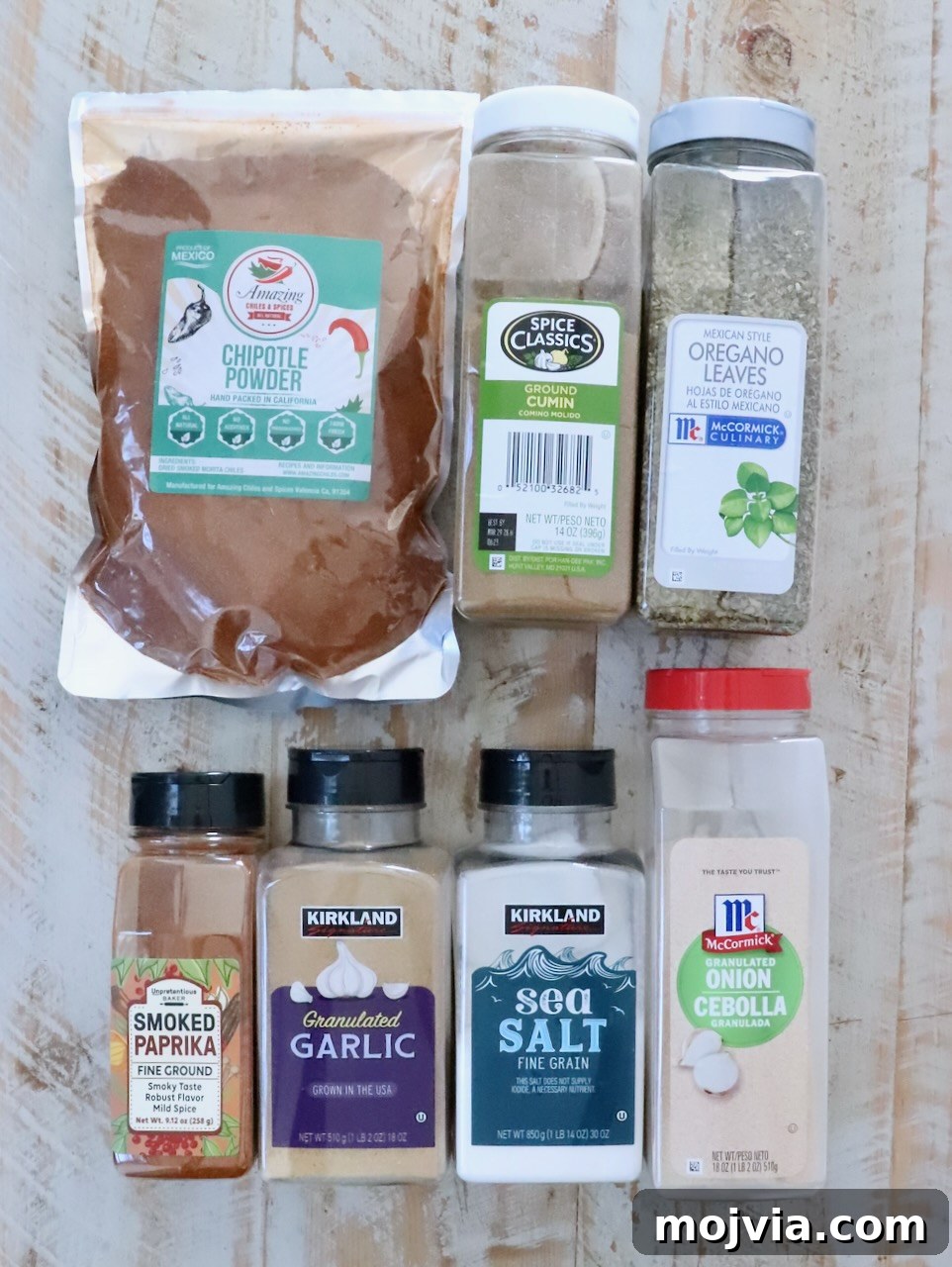 Homemade Chicken Taco Seasoning Mix for Flavorful Tacos 5 spices in plastic containers for chicken tacos seasoning lined up on a white wood table