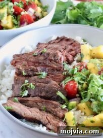Authentic Jamaican Jerk Steak Recipe 10 sliced steak in a bowl with mango salsa and rice