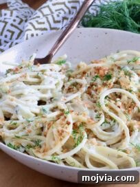 Creamy Dill-Pickle Pasta with Tangy Sauce 14 spaghetti in a creamy pickle sauce in a bowl with a fork, topped with toasted breadcrumbs