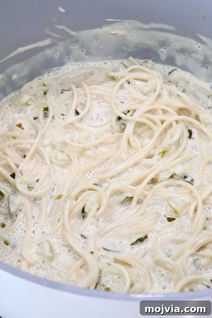 Creamy Dill-Pickle Pasta with Tangy Sauce 7 cooking spaghetti noodles in a creamy pickle sauce in a large pot