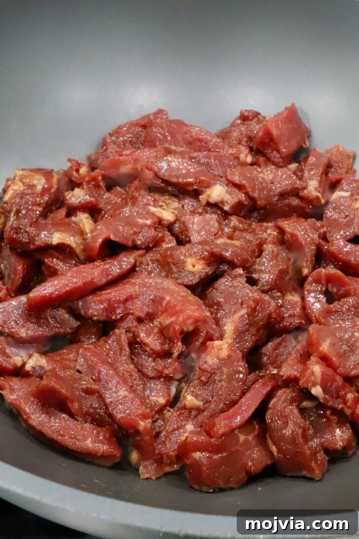 Korean Beef Bulgogi Lettuce Wraps Recipe 8 marinated strips of meat in a large wok on the stove