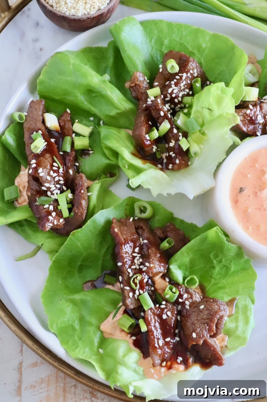 Korean Beef Bulgogi Lettuce Wraps Recipe 10 overhead image of Korean beef bulgogi in lettuce wraps with a creamy gochujang sauce on a plate